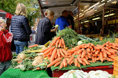 Marktstand auf dem Wochenmarkt  in Hamburg Sasel -  Stand mit Obst und Gemüse; Möhren / Karotten / Wurzeln.