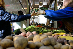 Marktstand mit Obst und Gemüse auf dem Wochenmarkt Tibarg im Hamburger Stadtteil Niendorf; Kisten mit Kartoffeln, frischen Bohnen und Möhren.