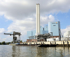 Blick auf das Kraftwerk Tiefstack in Hamburg Billbrook / Billwerder Bucht;  Schuten und ein Binnenschiff  mit Kohle an Bord werden am Kai des Kraftwerks entladen.
