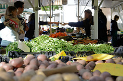Marktstand mit Obst und Gemüse auf dem Wochenmarkt Tibarg im Hamburger Stadtteil Niendorf; Kisten mit Kartoffeln, frischen Bohnen und Möhren.
