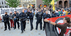 Antifaschisten gelang es spontan, direkt auf dem Hamburger Gänsemarkt Protesttransparente zu zeigen - eine Polizeikette schützt schnell die rechtsgerichete Veranstaltung.