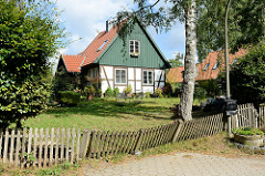Einzelhäuser / Landarbeiterhäuser an der Herrenhausallee im Hamburger Stadtteil Wohldorf-Ohlstedt; Fachwerk mit Holzgiebel - schiefer Holzzaun.