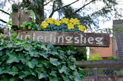 Straßenschild Winterlingstieg - Holzschild geschnitzt in der Gartenstadt von Hamburg Alsterdorf.