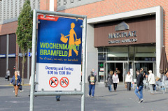 Informationsschild vom Bezirksamt Hamburg Wandsbek für den Wochenmarkt Bramfeld - im Hintergrund der Eingang zur Marktplatz Galerie.