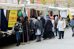 Marktstände mit Stoffen und Kleidung  auf dem Wochenmarkt in der Möllner Landstraße in Hamburg Billstedt.