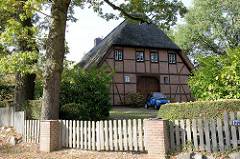 Historisches Wirtschaftsgebäude mit Fachwerk und Reetdach im Hamburger Stadtteil Groß Flottbek  - Holztor als Scheuneneinfahrt; Wohnhaus in der Baron Vogt Straße.