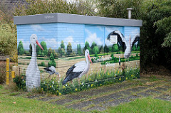 Verteilerkasten einer Energiestation mit Illusionmalerei / Fassadenbild versehen. Weißstörche auf den Kirchwerder Wiesen.