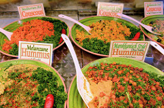 Marktstand mit mediterranen Delikatessen auf dem Wochenmarkt am Moorhof im Hamburger Stadtteil Poppenbüttel;leckerer Hummus und Couscous werden in Schalen angeboten.