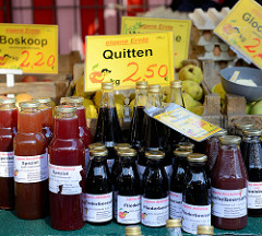 Wochenmarkt im Hamburger Stadtteil Neugraben-Fischbeck, Marktstand mit Obst, z. B. Quitten und Boskop-Äpfel sowie  Fruchtsäfte / Fliederbeersaft in Flaschen.