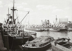 Historische Hafenmotive aus dem Hamburger Fotoarchiv. Frachtschiffe liegen im Segelschiffhafen - der Güterumschlag findet zur Kaiseite mit Kränen statt; zur Wasserseite werden die Waren mit bordeigenen Ladebäumen auf Schuten und Elbkähne geladen