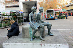 Kunst im öffentlichen Raum; Bronzeskulptur zwei Frauen mit Kind,     auf dem  Wochenmarkt Bei den Höfen in Hamburg Jenfeld.