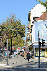 Sonniger Herbstnachmittag eines Sonntages an der Osterstraße  im Hamburger Stadtteil Eimsbüttel. Rechts die Geschäftsräume einer Videothek Ecke Hellkamp.