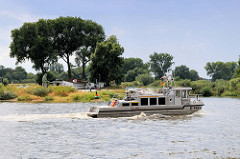 Blick über die Elbe zum Fähranleger Bleckede der Autofähre Amt Neuhaus;  das Motorboot X-Ray fährt im abwärts