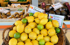 Marktstand  mit Obst und Gemüse  auf dem Wochenmarkt in Hamburg Finkenwerder, Finksweg; großer Korb mit Zitronen und Limetten.