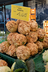 Marktstand mit Obst und Gemüse auf dem Wochenmarkt Sand im Hamburger Stadtteil Harburg; Sellerieknollen sind zu einer Pyramide aufgestapelt.