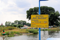 Blick über die Elbe zum Fähranleger Bleckede - Schild  der Autofähre Amt Neuhaus mit Betriebszeiten.