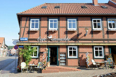 Café in der Straße Fiefhusen in Boizenburg/Elbe;  Tische auf dem Kopfsteinpflaster -eine Sammlung von Kaffeekannen in der Außenvitrine.