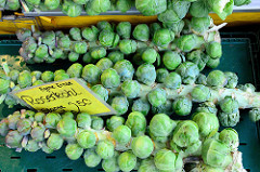 Obst und Gemüsestand auf dem Wochenmarkt am Moorhof im Hamburger Stadtteil Poppenbüttel; frisch geerntete Stangen mit Rosenkohl liegen  in der Auslage.