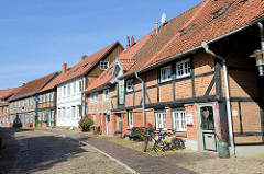 Denkmalgeschützte Wohnhäuser in der Großen Wallstraße von Boizenburg/Elbe; die Straße ist mit Kopfstein-Pflaster gepflastert.