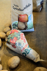 Wochenmarkt auf dem Marktplatz in Hamburg Rothenburgsort; Marktstand mit Obst und Gemüse, Papiertüten mit der Aufschrift frische Speisekartoffeln und frisches Obst.