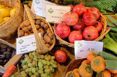 Obst und Gemüsestand auf dem Wochenmarkt   im Hamburger Stadtteil Ottensen / Spitzenplatz; Körbe mit Granatäpfeln, Walnüssen und Kaki.