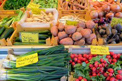 Marktstand mit Gemüse auf dem Wochenmarkt am Moorhof im Hamburger Stadtteil Poppenbüttel; Lauchzwiebeln, Radieschen, Gurken, Süßkartoffeln, Pastinaken und Rote Beete liegen zum Verkauf bereit.