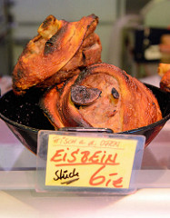 Wochenmarkt auf dem Marktplatz in Hamburg Rothenburgsort; Marktstand einer Fleischerei - Eisbein frisch aus dem Ofen.