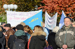 Aktionstag der überparteilichen Sammlungsbewegung Aufstehen - Sammelplatz der Demonstration mit dem Motto Würde statt Waffen auf dem Platz der Republik in Hamburg Altona.  Transparent mit der Aufschrift Die Waffen liefern die reichen, die Armen liefe