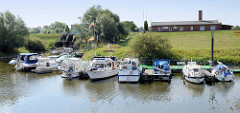 Sportboothafen / Marina am Stadthafen in Boizenburg/Elbe; Sportboote liegen am Steg hinter dem Deich.