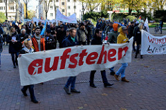 Aktionstag der überparteilichen Sammlungsbewegung Aufstehen - Start der Demonstration mit dem Motto Würde statt Waffen auf dem Platz der Republik in Hamburg Altona. Transparten mit der roten Aufschrift "aufstehen".