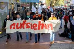 Aktionstag der überparteilichen Sammlungsbewegung Aufstehen - r Demonstration mit dem Motto Würde statt Waffen in der Ottenser Hauptstraße von Hamburg Altona. Transpart mit roter Aufschrift "aufstehen".