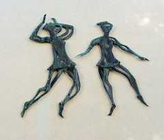 Bronzefiguren, tanzende Frauen als Relief an einer Hausfassade in der Harmsstraße von Hamburg-Harburg.