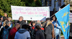Aktionstag der überparteilichen Sammlungsbewegung Aufstehen - Sammelplatz der Demonstration mit dem Motto Würde statt Waffen auf dem Platz der Republik in Hamburg Altona.  Transparent mit der Aufschrift Die Waffen liefern die reichen, die Armen liefe