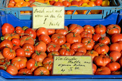 Gemüsestand auf dem Wochenmarkt Sand im Hamburger Stadtteil Harburg; frische Tomaten - Vierländer Platte aus eigenem Anbau - liegen in Kisten. Hinweisschild: Drück mich erst wenn ich dein bin! Danke