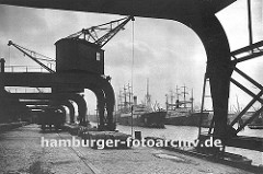 Alte Hamburgbilder - Fotos aus dem Hamburger Hafen, Krananlagen auf dem Hafenkai. Kräne am Amerikakai im Segelschiffhafen des Hamburger Hafens - ein Güterwagen der Hafenbahn steht auf den Gleisen am Kai und wird beladen.