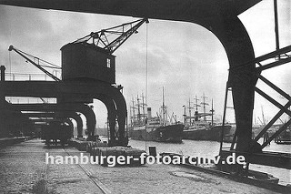 Alte Hamburgbilder - Fotos aus dem Hamburger Hafen, Krananlagen auf dem Hafenkai. Kräne am Amerikakai im Segelschiffhafen des Hamburger Hafens - ein Güterwagen der Hafenbahn steht auf den Gleisen am Kai und wird beladen.