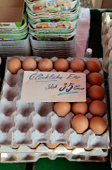 Frische Landeier in einer Eierpappe / Höckerlage auf dem Wochenmarkt in Hamburg Finkenwerder, Finksweg - Schild für glückliche Eier.