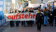Aktionstag der überparteilichen Sammlungsbewegung Aufstehen - r Demonstration mit dem Motto Würde statt Waffen in der Ottenser Hauptstraße von Hamburg Altona. Transpart mit roter Aufschrift "aufstehen".