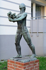 Bronzeskulptur,  schreitende  Frau mit Blumenstrauß in Hamburg-Harburg, Bildhauer Karl August Ohrt.