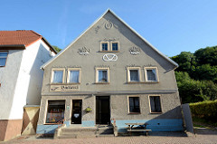 Altes Bäckereigebäude in der Berliner Straße von Oderberg. Die Fassade ist mit Blumengirlanden und Blumenkörben als Stuckrelief geschmückt in einer Brezel steht gegründet 1868.