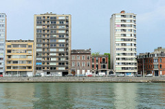 Wohnhäuser am Ufer der Maas in Lüttich / Liège; zweistöckige Wohnhäuser stehen zwischen Hochhäusern.