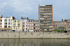 Blick über die Maas auf den Quai de la Dérivation in Lüttich / Liège; Wohnhäuser in unterschiedlichen Baustilen stehen am Flussufer.