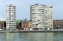 Wohnhäuser am Ufer der Maas in Lüttich / Liège; zweistöckige Wohnhäuser stehen zwischen Hochhäusern.