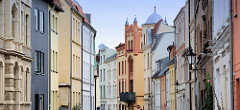 Farbige Fassaden an mehrstöckigen Wohnhäusern in unterschiedlichen Baustilen - Architektur in der Hansestadt Wismar.