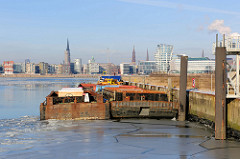 Zwei Schuten/Leichter liegen am AfrikaKai im Hamburger Südwesthafen; im Hintergrund der Stadtteil HafenCity mit seinen Neubauten.