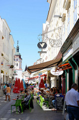 Fußgängerzone Obere Landstraße in Krems an der Donau, schmale Gasse mit historischen Bürgerhäusern - Café mit Außenbewirtung und Geschäften.