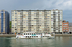 Hochhäuser am Ufer der Maas in Lüttich / Liège. Ein Fluss-Shuttle / La navette fluviale fährt die Maas flussabwärts.