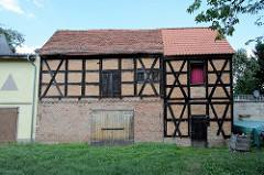 Alte Fachwerkspeicher an der Uferpromenade in Gartz / Oder. Die historischen Wirtschaftsgebäude stehen als Baudenkmal der Stadt unter Denkmalschutz.