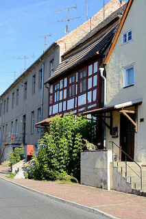 Wohnhäuser in unterschiedlichem Baustil in der Berliner Straße von Oderberg. Ein denkmalgeschütztes Fachwerkgebäude steht eingequetscht zwischen anderen Häusern.