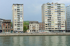 Wohnhäuser am Ufer der Maas in Lüttich / Liège; zweistöckige Wohnhäuser stehen zwischen Hochhäusern.